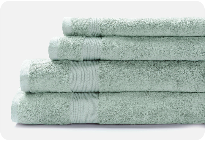Nos serviettes de bain en coton modal Seafoam présentées en pile sur un fond blanc.