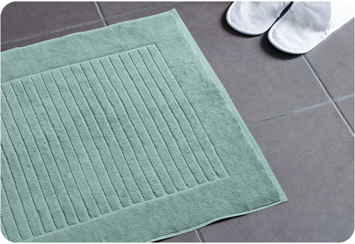 Our Seafoam modal cotton bath mat shown on a tiled floor.