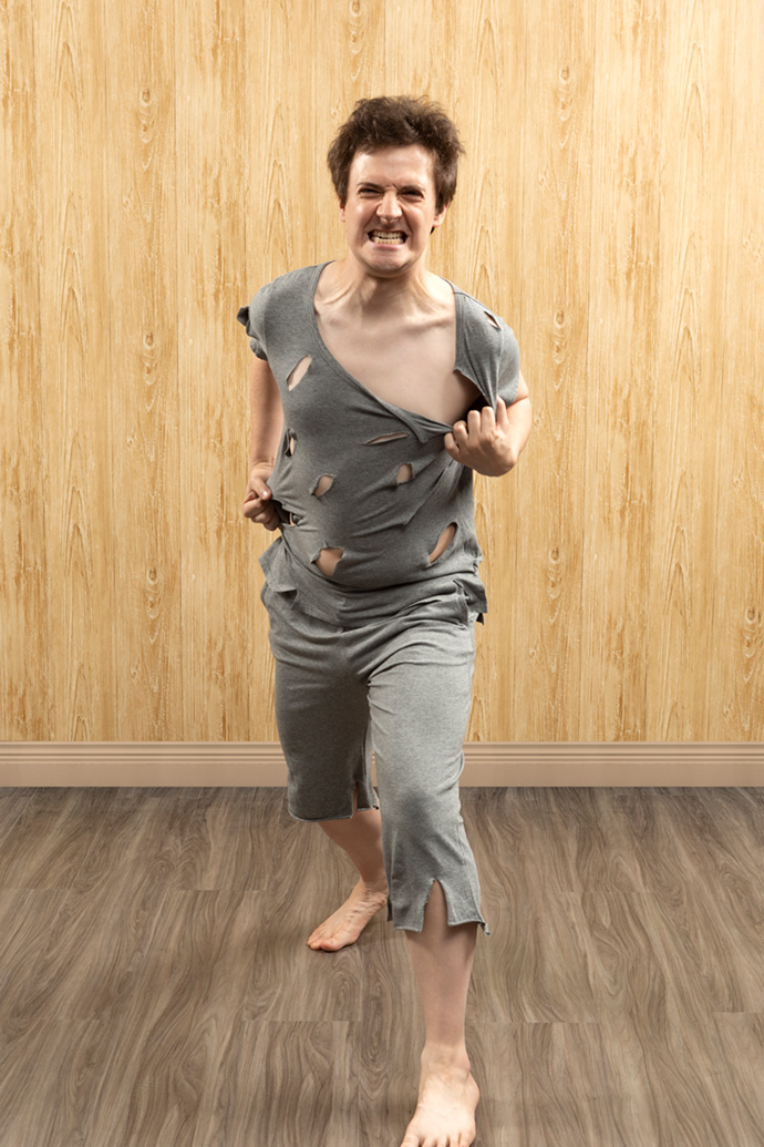 Man with fluffy hair and an angry expression tearing out of his shredded loungewear like a werewolf. Man with fluffy hair and an angry expression tearing out of his shredded loungewear like a werewolf.
