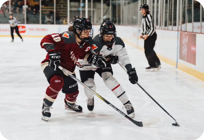 Hockey player Brigitte Laganière in close competition for the puck on the ice, wearing the official PWHL Montreal maroon jersey and hockey attire.