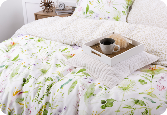 Angled view of a white bed dressed in our Faroe Duvet Cover with a coffee cup on a tray overtop.